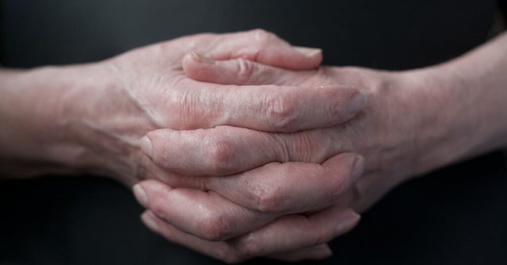 Close-up of senior adult hands showing texture and age in soft lighting.