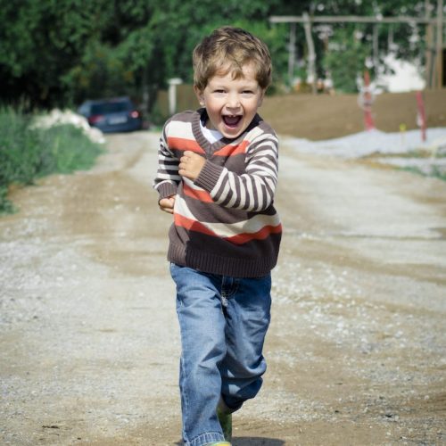 Boy Wearing Red, Brown, and White Stripe Sweater Running Photo